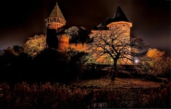 Castle towers in night light. Castle fortress at night. Night lights of castle fortress. Fortress at night lights