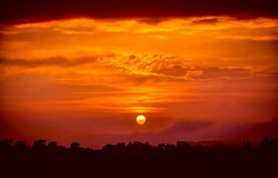 Deep orange sundown in sky at sunset. Sundown silhouette in sunset sky