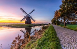 Windmill in Holland. Mill by the river at dawn. Windmill at dawn