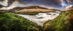 Panorama of a stormy river in a mountain valley. River valley panorama. River rapids in river valley panoramic landscape
