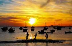 Fisherman fishing at sunset sea