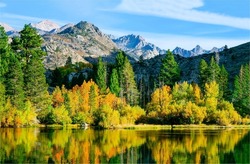 Autumn foliage of trees in a mountain forest. Mountain lake in autumn. Autumn lake in mountains. Autumn landscape