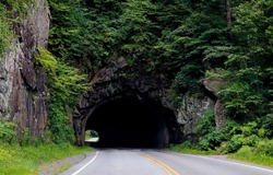 The road through the tunnel in the mountain. Road in mountain rock tunnel. Tunnel road way. Road way in tunnel
