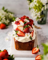 Strawberry and cream cheese summer cake on white marble board. Homemade summer dessert in spring decoration. brunch ideas. easter dessert.