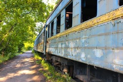 Old shabby wagon without windows. Decommissioned blue railway wagons. Rusty, peeling passenger wagons