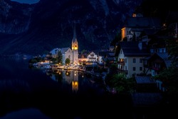 Scenic picture-postcard view of famous Hallstatt mountain village in the Austrian Alps, Salzkammergut region, Hallstatt, Austria. Hallstatt village on Hallstatter lake in Austrian Alps at night.