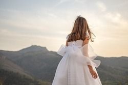 Girl with communion dress in a natural mountainous environment