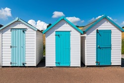 Colorful small beach houses. Multicolored beach sheds. Variety of painted beach shacks. Beach hut. Torbay, South Devon. UK.