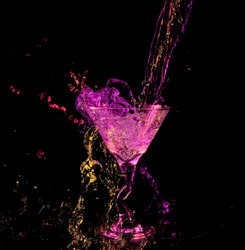 Martini glass with a neon splash of colorful drink in purple red green yellow neon colors