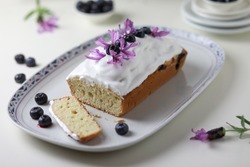Bundt cake with glazing decorated with fresh blueberry fruits and lavander flowers. 