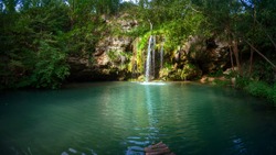 Waterfall and a beautiful lagoon lake for relaxing in the summer forest.