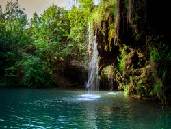 Waterfall and a beautiful lagoon lake for relaxing in the summer forest