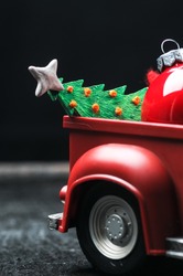 new year mockup of a red car body with a christmas tree and a christmas tree toy on a black background
