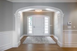 Grand foyer with white doors and elegant staircase and wraught iron