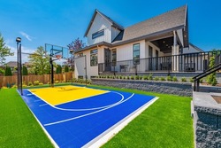 Large estate home with sport court backyard sunshine blue sky landscaping and deck