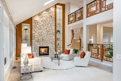 Mid century craftsman house interior living room foyer home office with wood panel walls staircase creative wooden railings stone fireplace in warm white tones and orange accent colors