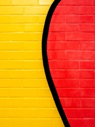 Red and yellow colors painted on a brick wall background. Empty space on vivid color brick wall texture, vertical style.