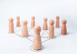 Leader woman, influencer, wooden figures with goal target icon on faces, standing in front of the team with connection symbol on white background, minimal style. Leadership, empowerment concept.