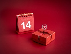 3d love like heart icons floating on small red present gift box with February ,14 Valentine's day on desk calendar cover on red background. Special gift for Valentine's Day, minimal style.