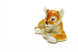 Antiques, art, collectibles. Swap meet. Isolated over white background. figurine of a tiger lying on the floor, glazed ceramics
