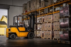 Warehouse man worker with forklift. Warehouse worker driver in loading by forklift stack loader