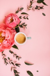 Arch shape of delicious fresh morning espresso coffee, eucalyptus leaves and blossoming coral peonies on the tender pink background, top view, flat lay