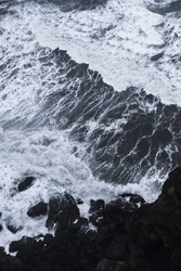 Aerial view on Atlantic ocean in Iceland. Wild waves crushing into the black rocks, view from above