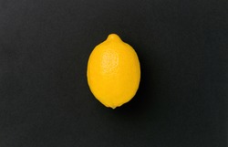 whole lemon on black background, top view, minimalism, flat lay