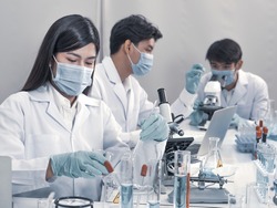 Asian scientists work in hospital pharmacology science research lab. Woman medical scientist and researchers teamwork analyzing innovative virus protective vaccines in health care biology laboratory