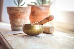 Tibetian singing bowl in cozy interior, witt ceramic pot with succulents, insence for meditation and self care. 
