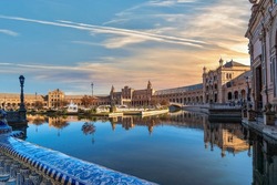 Sunset view of the small public pond and buildings in the Plaza de Espana, or Spanish Square, in Seville, Spain