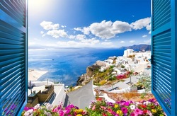 View from an open window of a luxury resort of the Aegean sea, caldera, coastline and whitewashed town of Oia, Santorini, Greece.