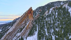 Beautiful flatirons of boulder Colorado covered in Snow during sunset