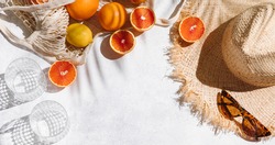 Summer fashion banner flat lay on white background. Holiday party, vacation, travel, tropical concept. Straw hat, sunglasses and citrus fruits. Palm shadow and sunlight, sun. Top view, copy space