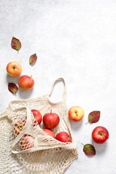 Red ripe apples in shopping bag on white background. Autumn apple flat lay, top view, copy space. Autumn harvest, apple cooking concept.
