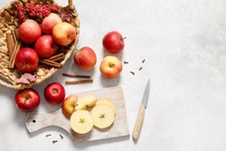 Fresh ripe red apples with knife and chopping board on white table background. Autumn apple flat lay, top view, copy space. Autumn harvest and cooking apple meal, apple pie concept