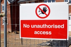 Construction site building of new homes health and safety warning notice on metal fence