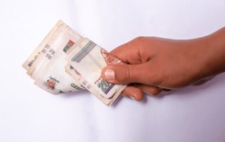 A hand holding Egyptian money in the denomination of 200 pounds. Isolated on the white.