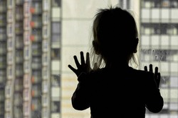Girl looks out the window against the background of apartment building concept stayathome