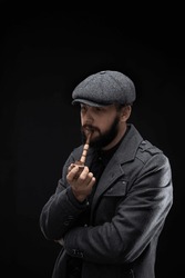 a bearded stylish man smoking a pipe man smokes a pipe on a dark background