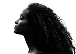 Greyscale head shot portrait in profile of a beautiful proud young woman with gorgeous curly black hair raising her head and stretching her neck over a white background