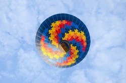 Hot air balloon, seen from below, with blue sky in the background
