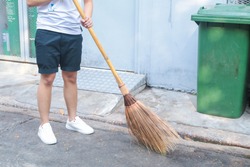Man using broom sweep the street or floor garbage cleaning service concept city.Maintenance worker in park garden cleans the roads with broom .Copy space