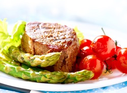 Grilled Beef Steak Meat with Vegetables - Asparagus, Cherry Tomato and Lettuce. Steak Dinner. Food