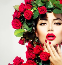 Beauty Fashion Model Girl Portrait with Red Roses Hairstyle. Red Lips and Nails. Beautiful Luxury Makeup and Hair and Manicure Vogue Style