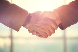 Business handshake. Business handshake and business people concept. Two men shaking hands over sunny office background. Partnership, Deal