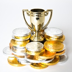 A success or victory concept with a gold trophy or cup surrounded by gold and silver coins in the form of prize money