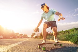 Man on longboard skate at sunset
