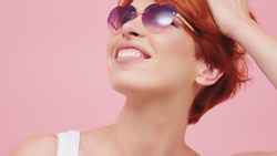 Portrait of beautiful middle aged red head woman with heart shaped glasses. Beauty shot. 