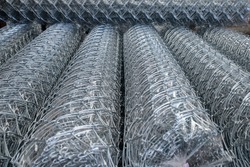 Rolls of chain link fence wire mesh placed them in storage awaiting for sell or disposal wire fence. seamless chain link fence. industrial fence